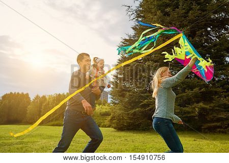 Happy Family With Colorful Kite On Nature. Sunlight.