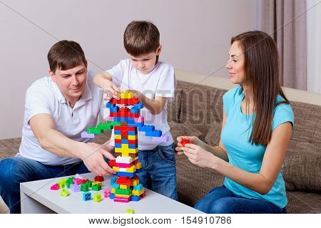 Family playing board game at home. Happy