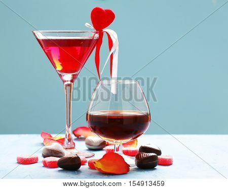 Alcoholic drinks for the festive party. Chocolate candy hearts. Gift for a holiday. Date on Valentines Day