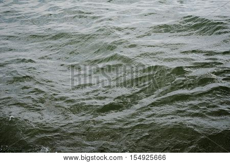 Dark blue background of water surface. Ocean water surface texture. Deep sea waves
