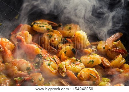 Hot shrimp fried in a pan on old wooden table
