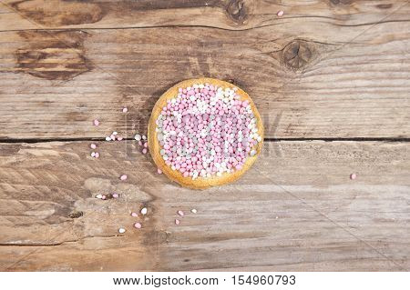 Traditional Dutch birth celebration biscuit with pink muisjes on wooden background