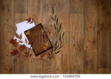 Craft paper letter with white lasts around autumn leaves