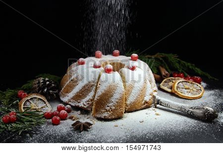 Christmas  bundt cake  with red berries on a black background