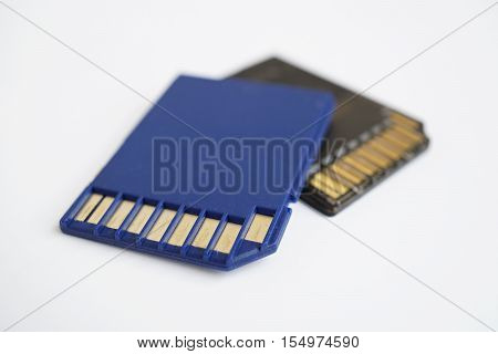 Two isolated plastic blue and black compact memory card (SD card - Secure Digital card) used in cameras, computers and video cameras in a blue color with metal connectors in the golden color