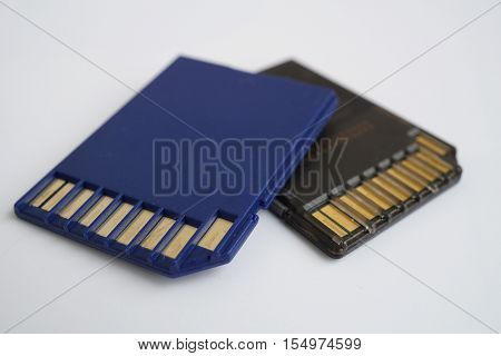 Two isolated plastic blue and black compact memory card (SD card - Secure Digital card) used in cameras, computers and video cameras in a blue color with metal connectors in the golden color