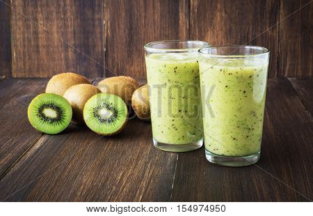 Kiwi green smoothie in glass on wooden background selective focus toned horizontal