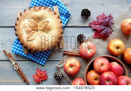 Apple pie with ingredients cinammon sticks and autumn leaves