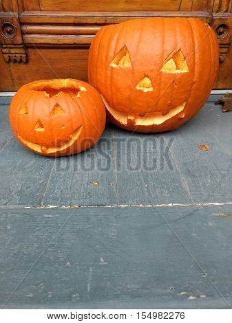 Two Halloween jack-o-lantern carved pumpkins with copy space