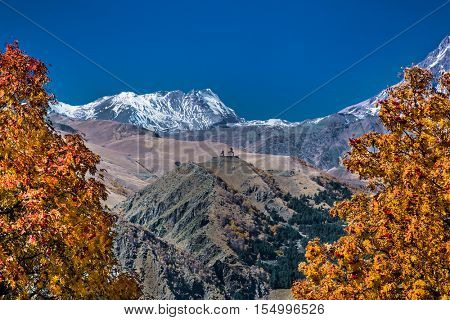 Panoramic view on Kazbegi (Stepantsminda) village with Gergeti Tsminda Sameba church behind, Georgia,  Europe. 