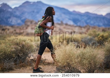 fit african american woman hiking through alabama hills park in california