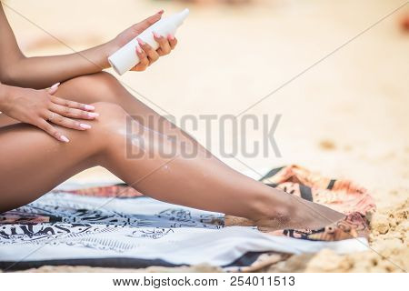 Sunscreen Suntan Lotion Spray Skincare Product Closeup Of Woman Putting Tanning Oil On Her Legs. Han