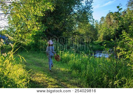Young Girl Walking On A Path Through Green Woods Carrying A Birchbark Basket
