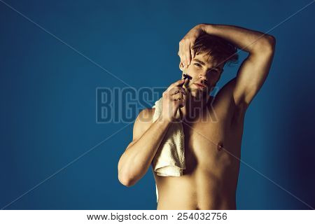 Man Or Bearded Macho With Naked Torso Shaving Beard Hair With Safety Razor And Bathing Towel On Shou