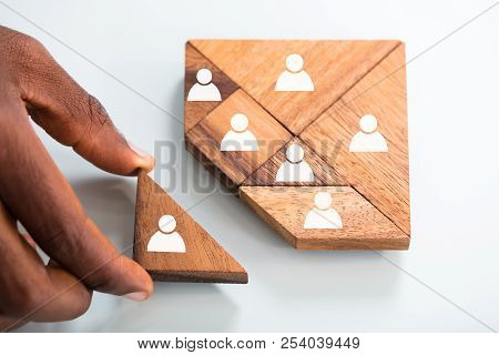 Person's Hand Completing Tangram Puzzle
