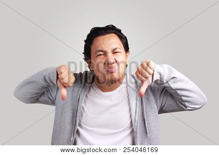 Portrait Young Asian Men Wearing Jacket Upset With Thumbs Down