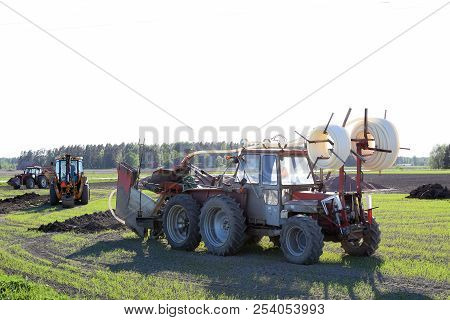 Tractors And Excavator On The Field Making A Drainage.