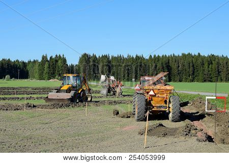 Tractors And Excavator On The Field Making A Drainage.