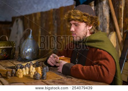 Portrait Of Man In Russian Ethnic Suit Playing Chess