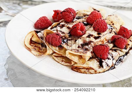 Delicious Golden Palacinky Pancakes Or Czech Pancakes With Fresh Raspberries And Sweet Chocolate Syr