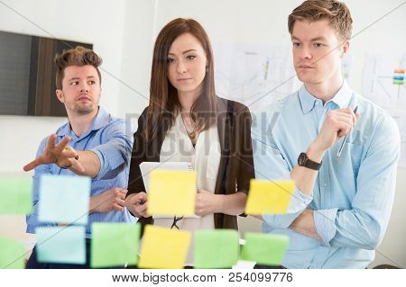 Businesswoman Looking At Strategies On Adhesive Notes By Colleag
