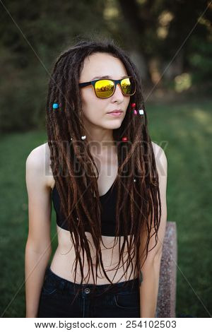 Unusual Slender Girl With Dreadlocks In The Topic And Sunglasses