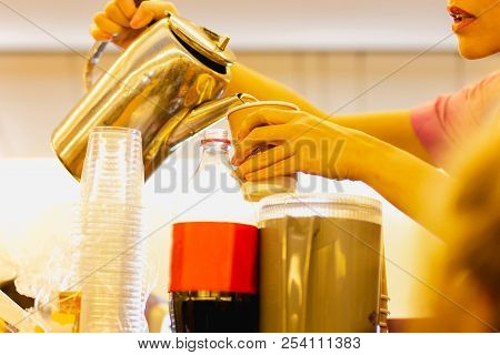 Shot In Low Light Flight Attandant Serving A Drink To Passengers On Seats During Flight Time.