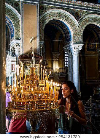 Athens, Greece - June 30, 2018. Parishioner Light Candles In The Nave Of The Metropolitan Cathedral 