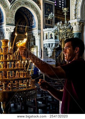 Athens, Greece - June 30, 2018. A Employee Extinguishing Candles In The Metropolitan Cathedral Of Th