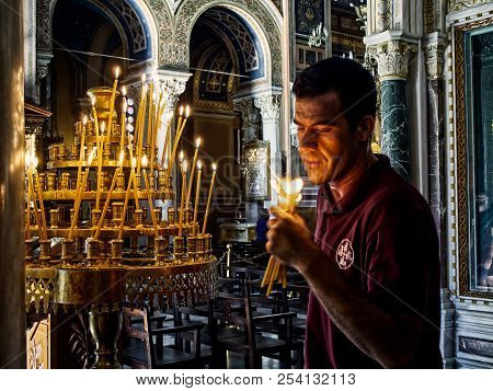 Athens, Greece - June 30, 2018. A Employee Blowing Out Candles In The Metropolitan Cathedral Of The 