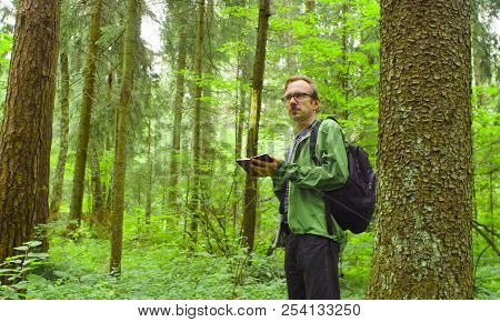 The Ecologist In A Forest Writing In Notebook.