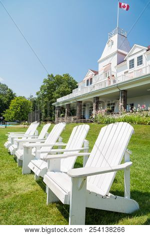 Windermere, On, Canada - July 21, 2017: A Set Of Muskoka Chairs Sitting On The Lawn In Front Of The 