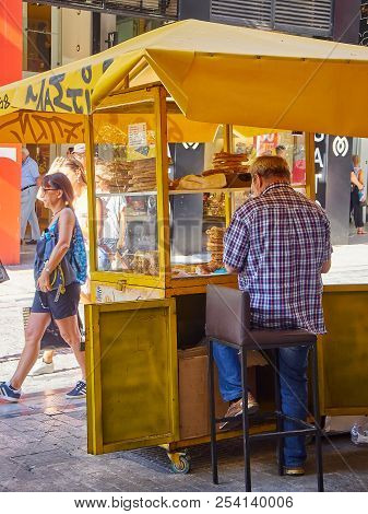 Athens, Greece - June 30, 2018. A Vendor In Front Of His Koulouri Stall In A Street Of Athens. Attic