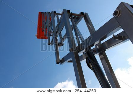 The Used Red Boom Lifts With The Blue Sky Background In The Warehouse.technology.