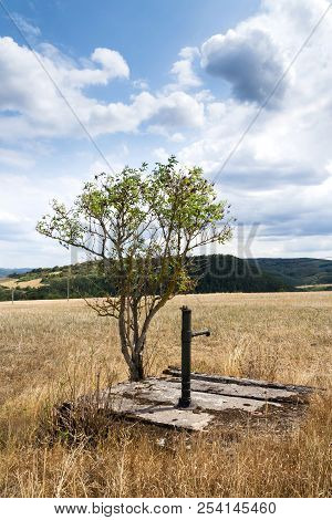 Old Pump With Dry Soil, Dramatic Cloudy Sky, Water Shortage