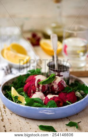Beet Falafel With Tahina  Sauce And Green . Salad Selective Focus