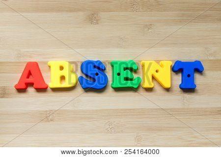 Color Plastic Alphabet In Word Absent On Wood Background