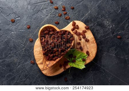 Brown Raisins In Bowl And Green Leaf. Top View Of Dried Grapes With Copy Space.