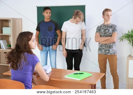 Teenage girl sitting at desk in classroom