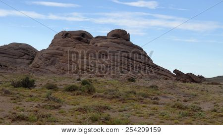 Monolithic Stones In The Steppes, Scant Vegetation, Blue Sky