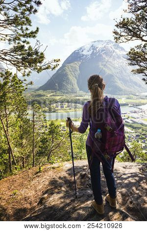 Girl Hiker With A Backpack And Trekking Pole Sitting And Looking On Romsdalsfjorden And Andalsnes, N