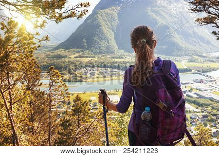 Girl Hiker With A Backpack And Trekking Pole Sitting And Looking On Romsdalsfjorden And Andalsnes, N