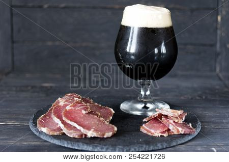 A Glass Of Dark Beer. Beer And Dried Meat.