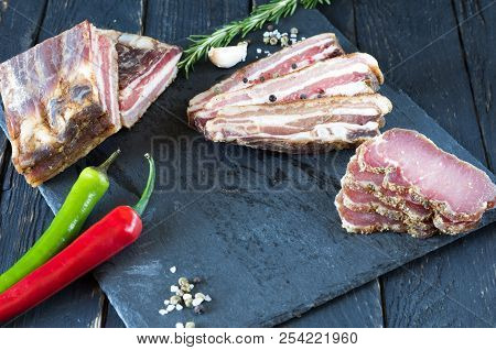 Slicing Jerky Meat On A Black Board.