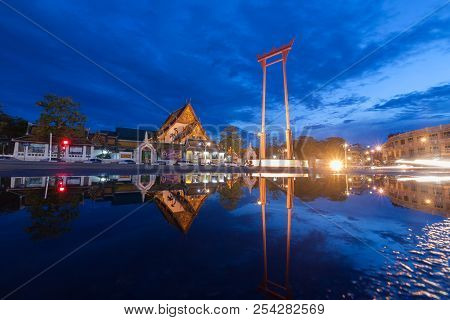 Reflection Of The Giant Swing And Suthat Temple At Twilight In Bangkok, Thailand