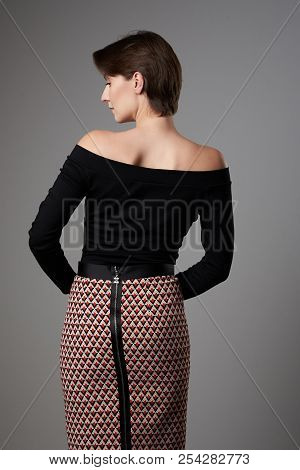 Woman Standing In Casual Coth Back View On Gray Background