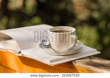 Cup Of Hot Coffee For Brackfast And Book  On Wooden Balcony Near River And Mountain Background. Coff