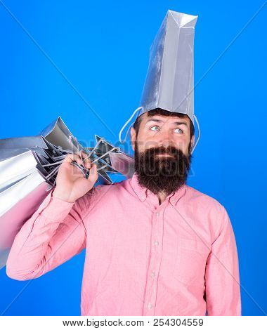 Man With Beard And Mustache Carries Shopping Bags, Blue Background. Hipster On Deamy Face With Bag O