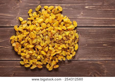 Lot Of Whole Dry Golden Raisins Sultana Variety Heap Flatlay On Brown Wood