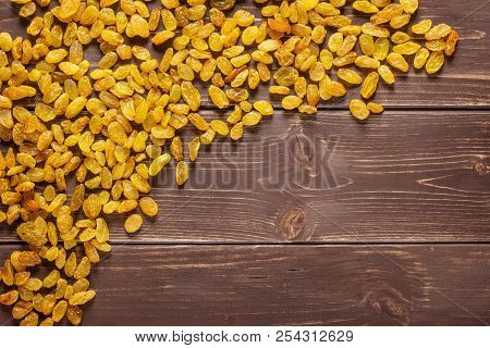 Lot Of Whole Dry Golden Raisins Sultana Variety Left Upper Corner Flatlay On Brown Wood